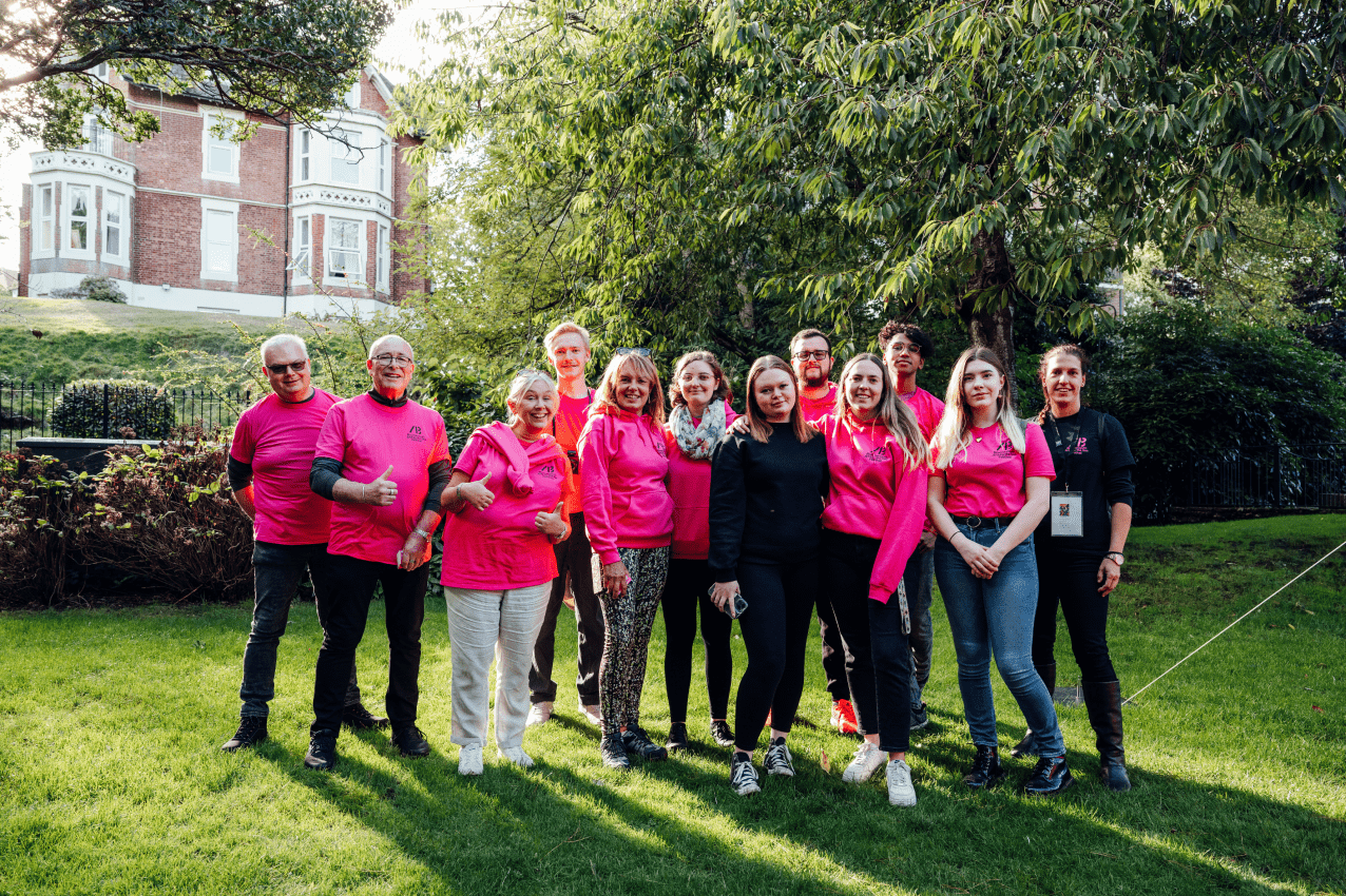 Group of people wearing pink standing on the grass