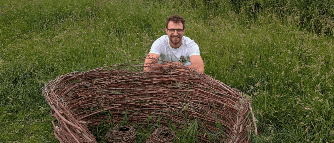 Artist shown holding wicker artwork